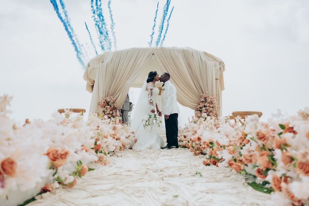Elegant beach wedding setup with floral arrangements and white decor.