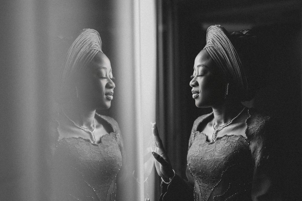 Moody window light portraits in black and white with dramatic shadows.