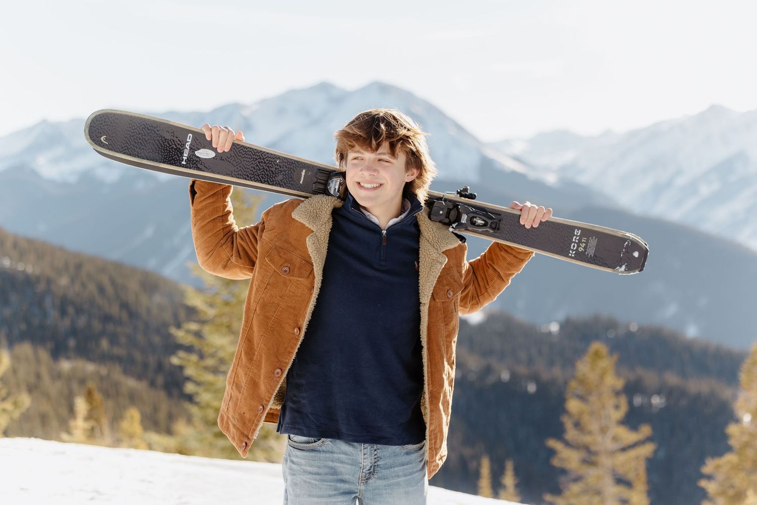 A boy posing on Aspen Mountain for his senior photo session with Kelly Elizabeth Photography.