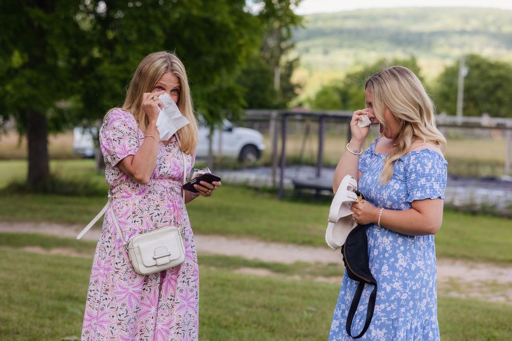 A series of outdoor photos showing people in floral dresses and blue outfits embracing in a grassy setting during golden hour.
