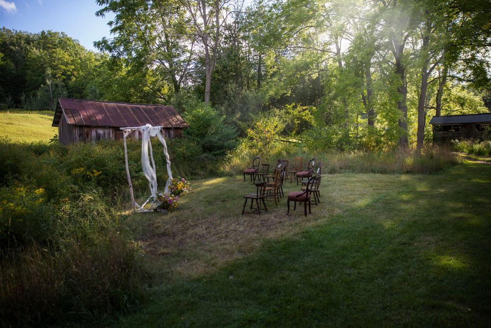 Lost woods farm ceremony set up among willow trees and wooden chairs