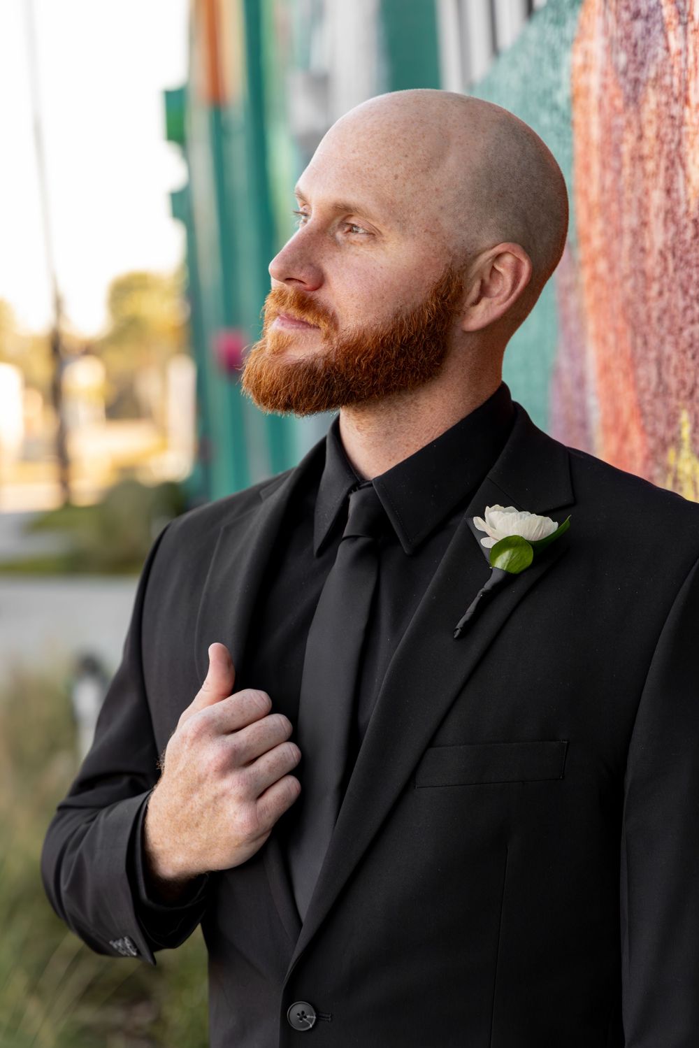 A man in a black suit adjusts his collar while looking to the side in a series of professional portraits.