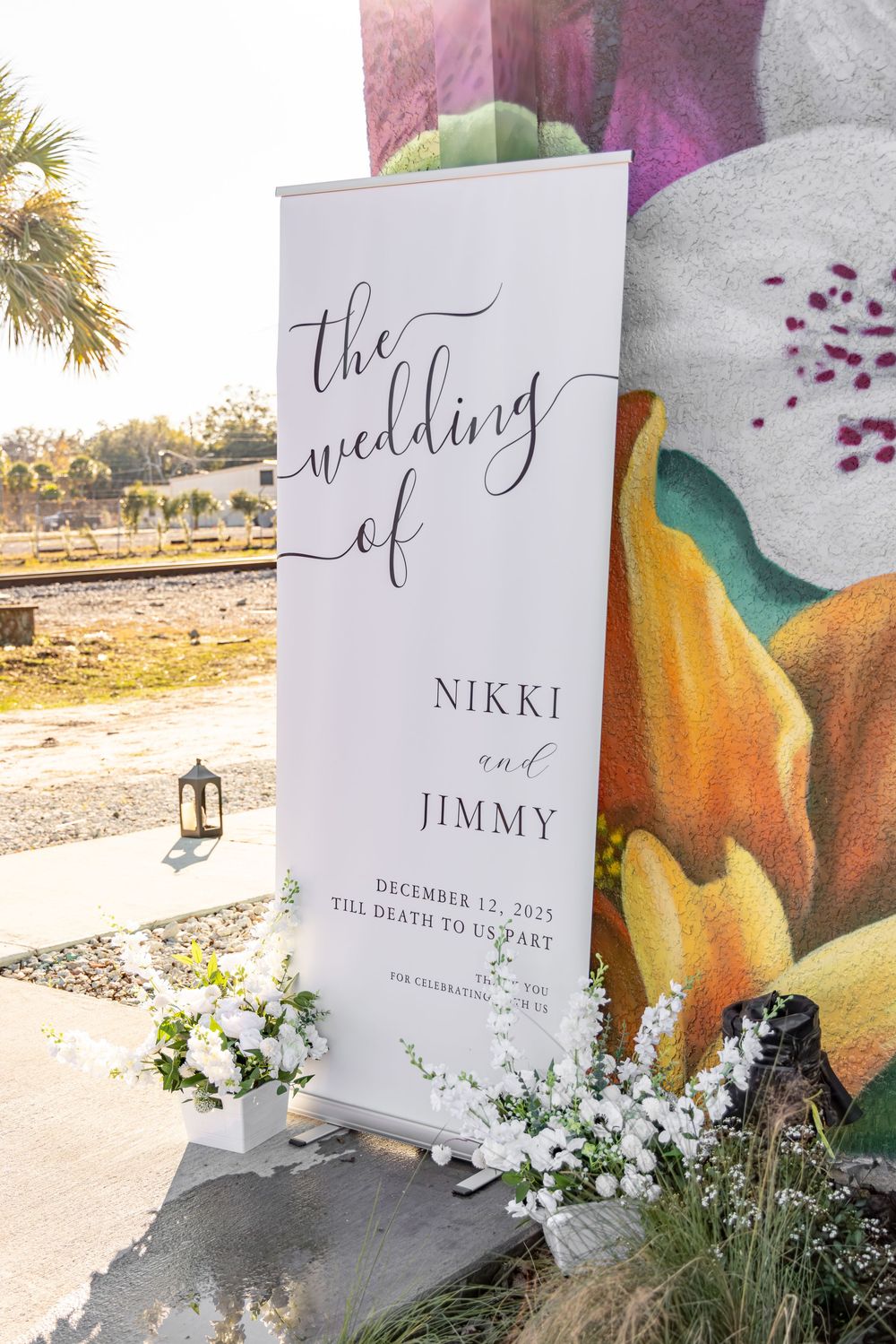 Wedding invitation cards displayed outdoors with pumpkins and white flowers against a rustic background.