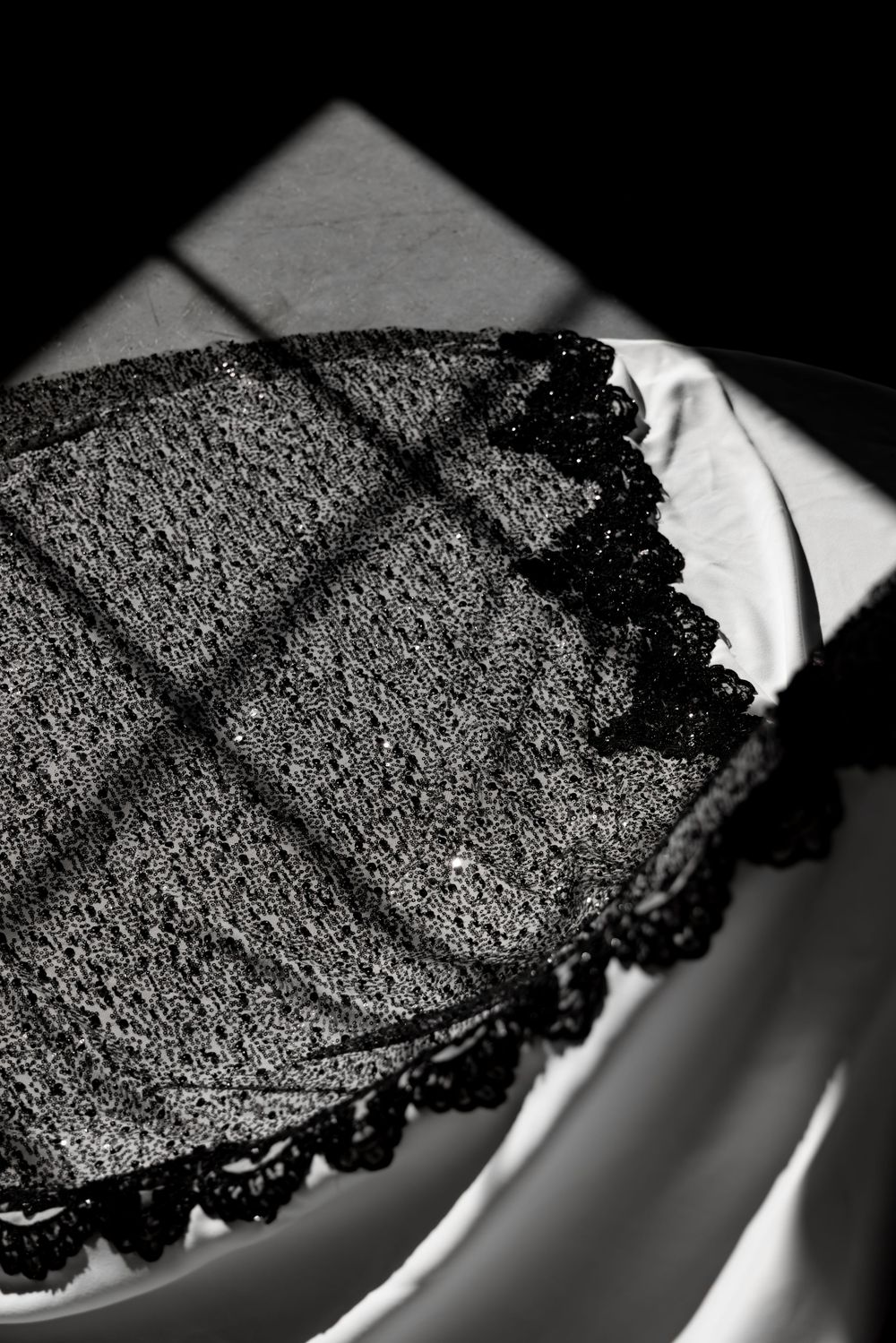 Close-up sequence of a dark, textured slice of burnt or charred bread against a white surface in dramatic lighting.