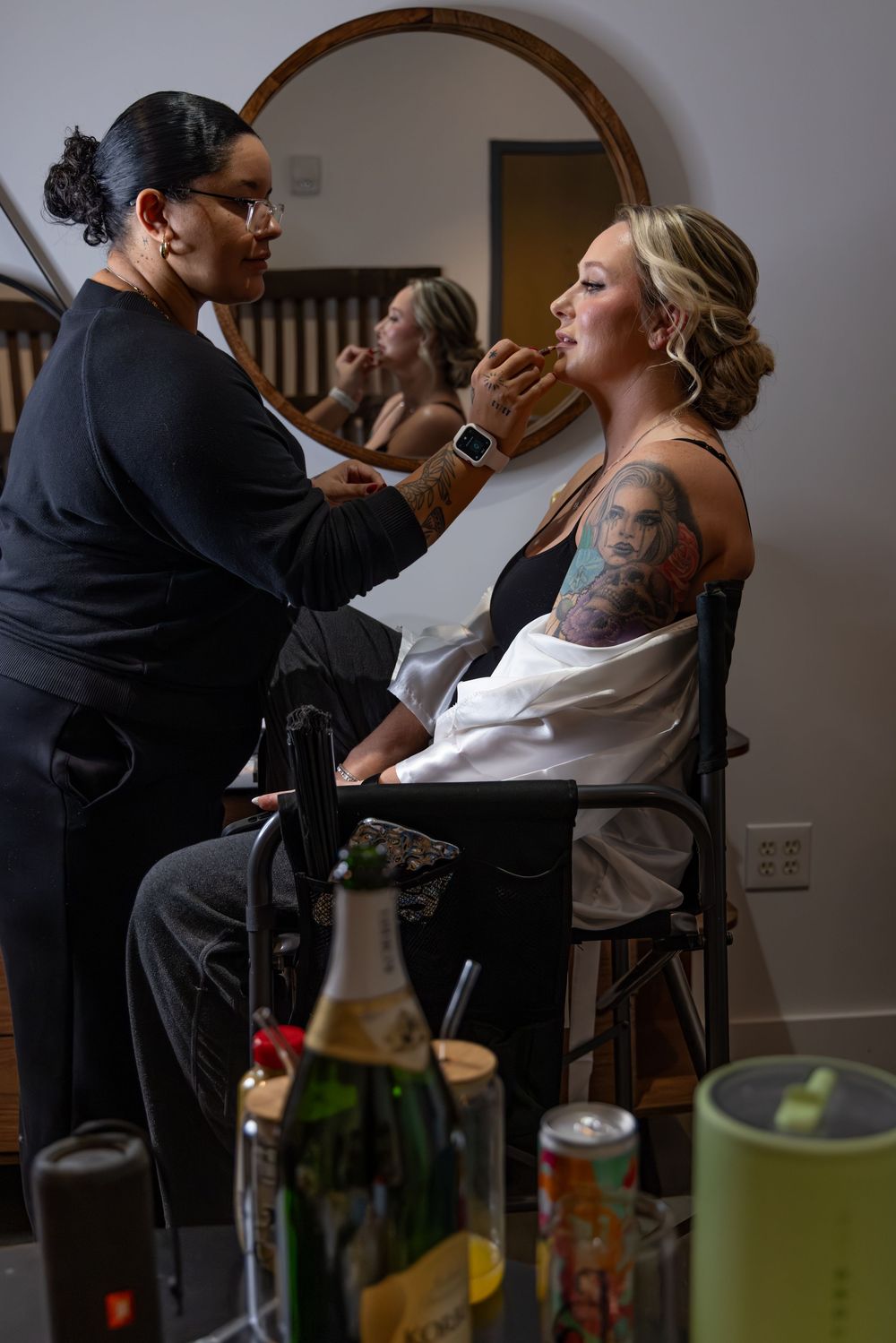 Makeup artist applying cosmetics to bride during wedding day preparation.