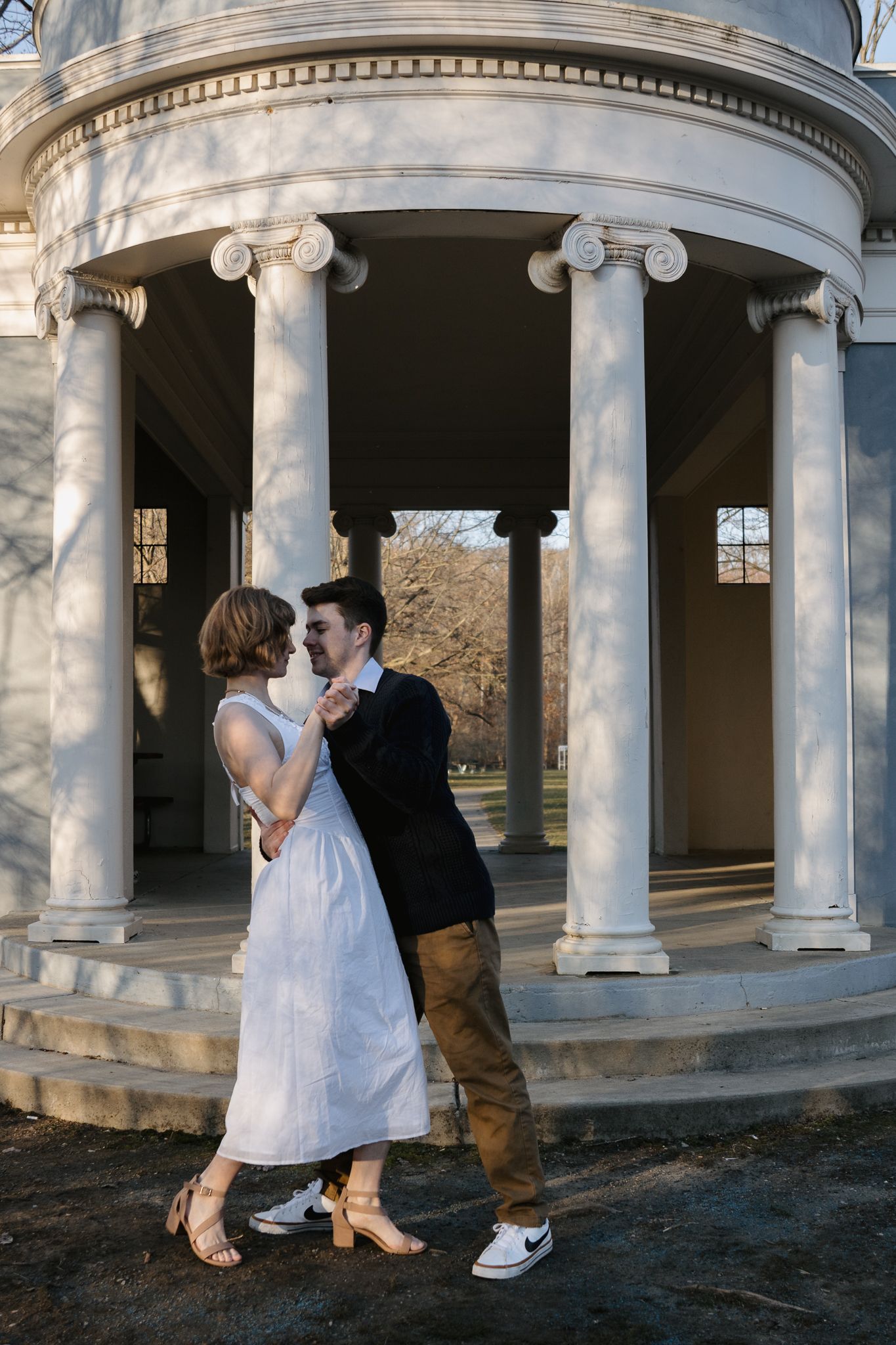 A man and woman dancing in front of a Greek Revival structure at Island Park in Ann Arbor.
