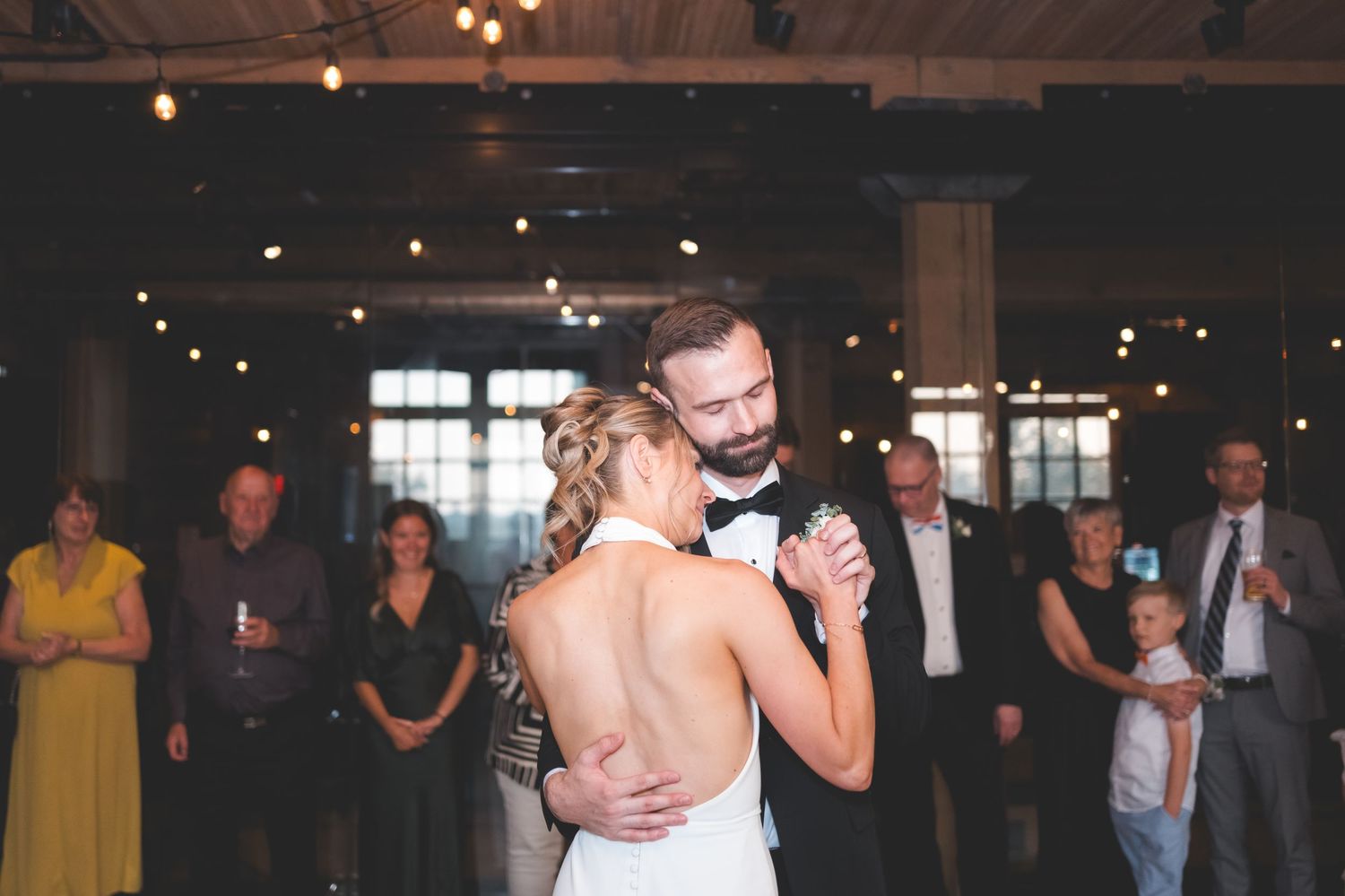 A romantic photo sequence of a couple in wedding attire embracing against a red wooden wall background.