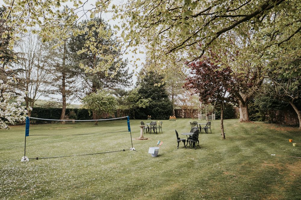 Wide landscape view of a green open field with trees and picnic tables scattered throughout the area.