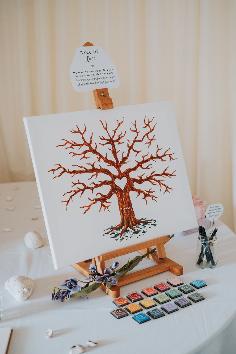 A series of photos showing a tree painting progression on white paper displayed on a wooden easel with art supplies.