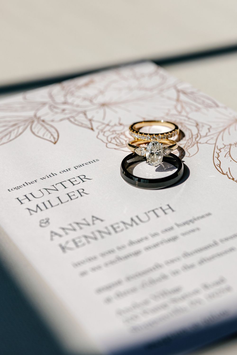 Elegant wedding invitation with gold rings photographed in soft focus.