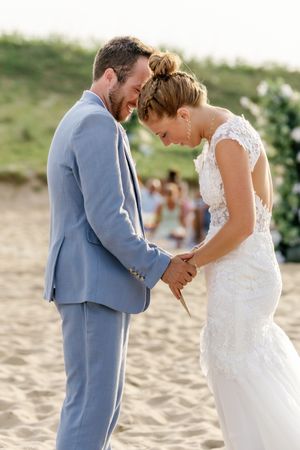 Couple shares intimate laughter during their beach wedding ceremony.