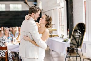 Wedding reception dance sequence showing couple spinning in bright indoor venue.