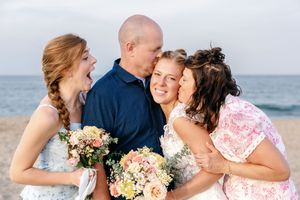 A joyful beach wedding moment against an ocean backdrop.