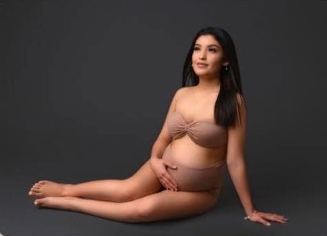 A flowing purple maternity dress with off-shoulder design and ruffle details shown from multiple angles on a gray backdrop.