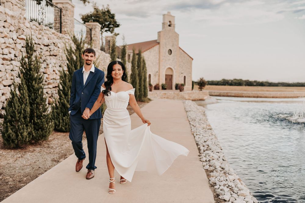 a bride and groom walk hand in hand along the water's edge at chapel at palacios