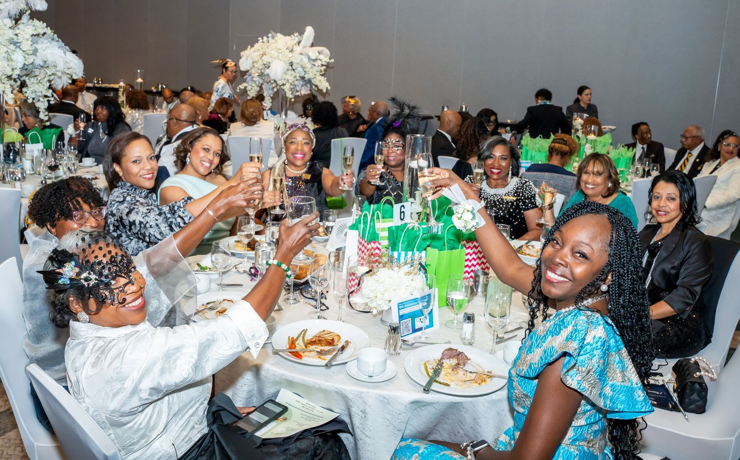 Guests enjoying dinner and conversation at a formal banquet with festive table settings.