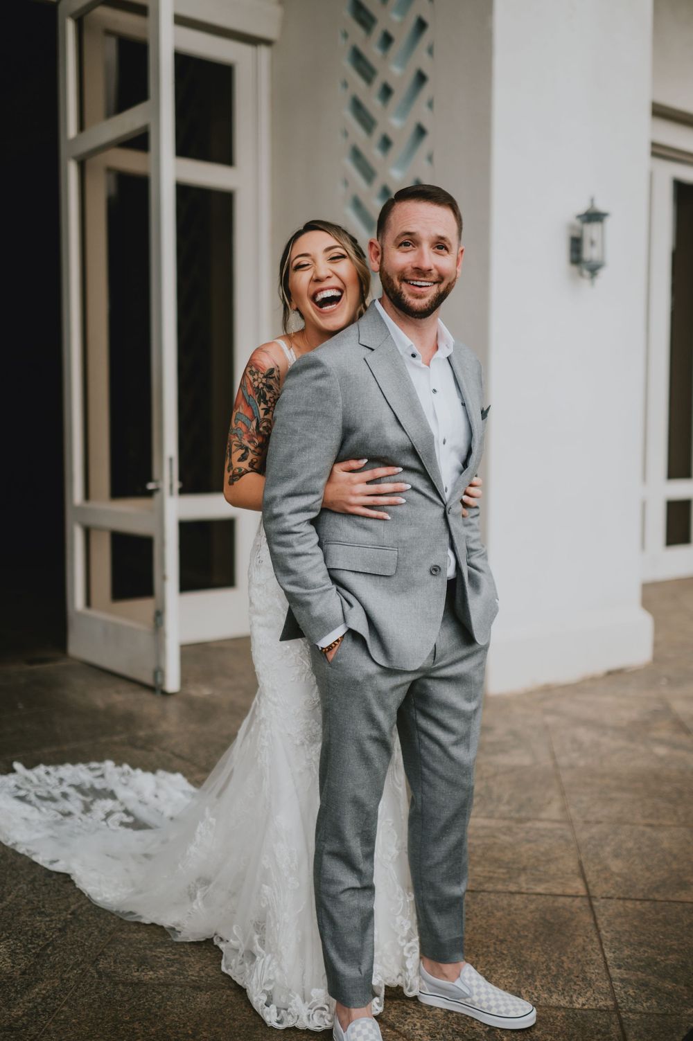A happy couple shares joyful moments in their wedding attire, with the bride wearing sneakers and a flowing white dress.