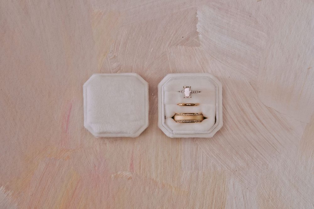 Detailed close-up of a white electrical outlet and wall plate mounted on a light colored wall surface.