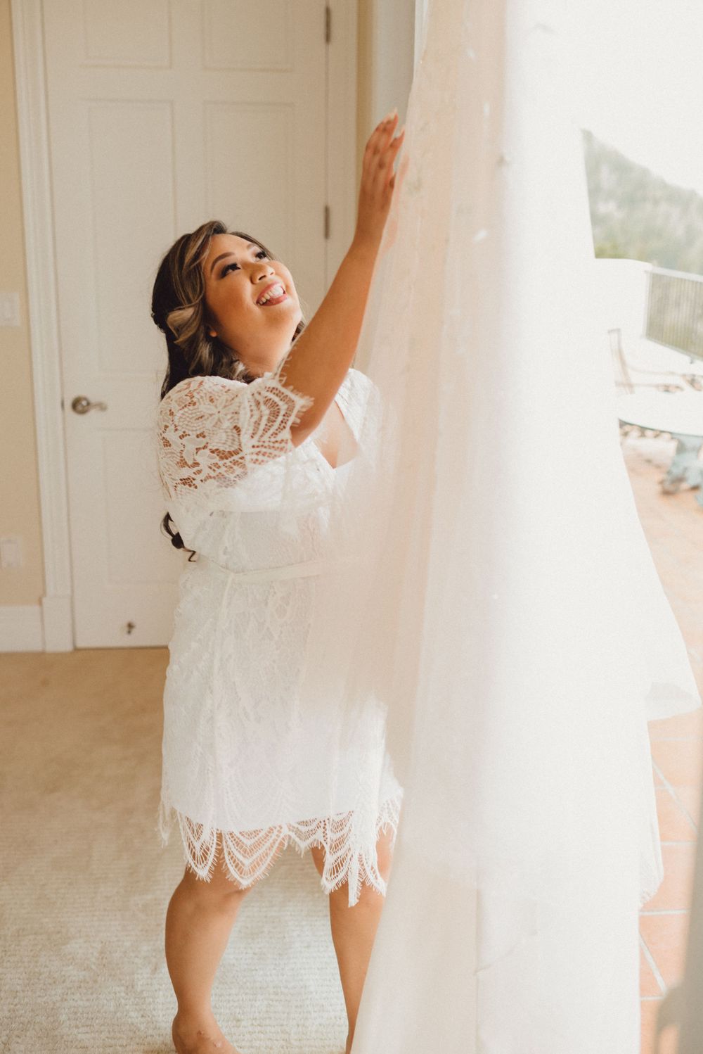 Joyful scene of a white lace dress twirling against a bright window backdrop.