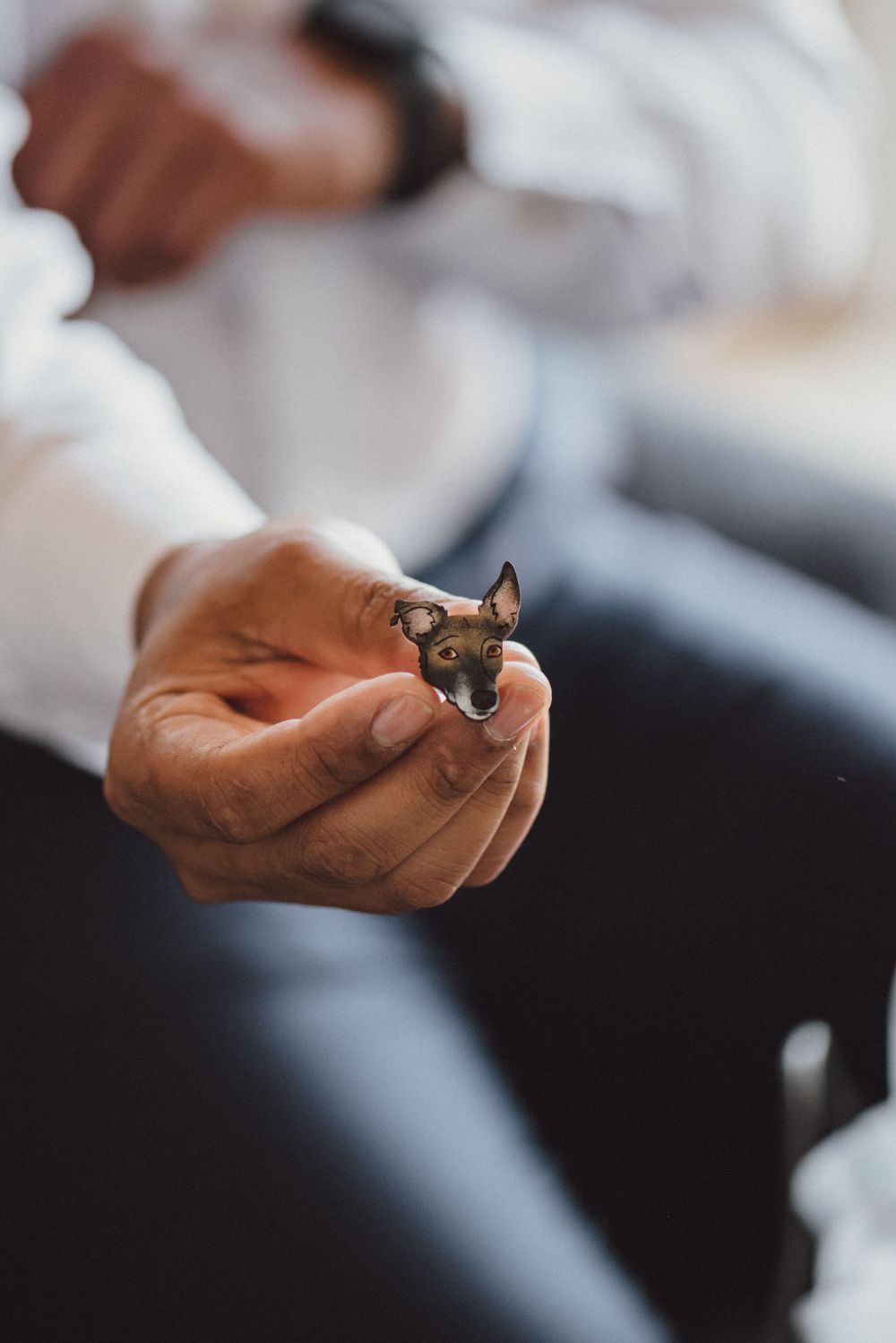 Close-up shot of hands holding small wedding rings.