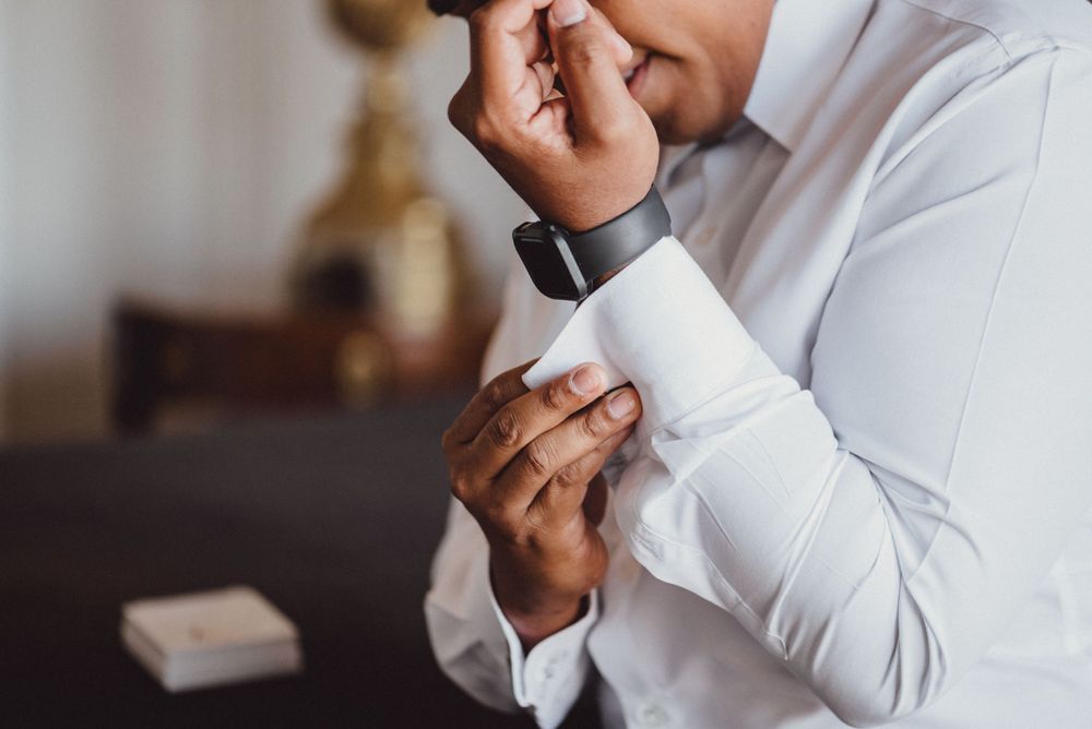 Person in white formal attire reading a letter with emotional expression.
