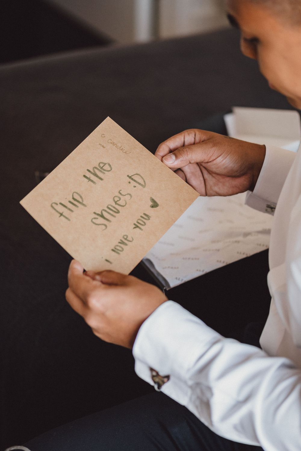 Hands holding handwritten wedding vows or letters on rustic paper.