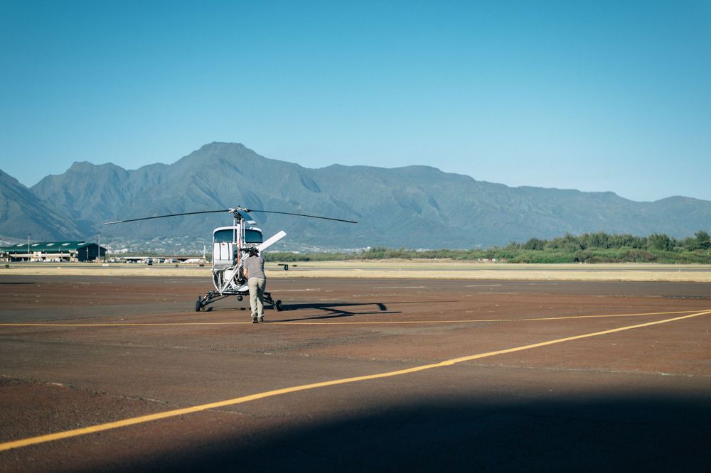 Wide panoramic view of airfield with mountains and clear blue sky.