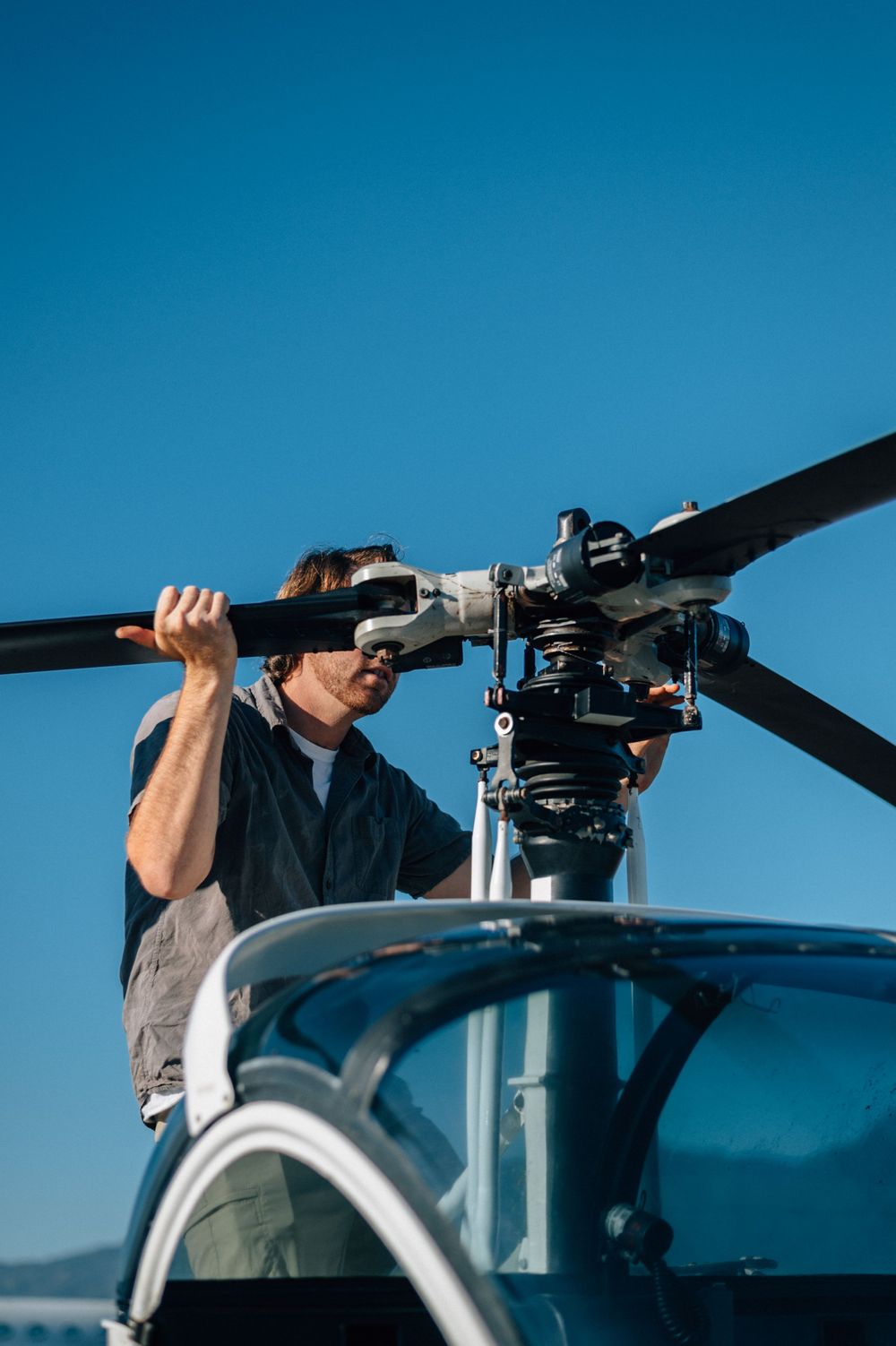 Close-up view of helicopter maintenance check on main rotor assembly.
