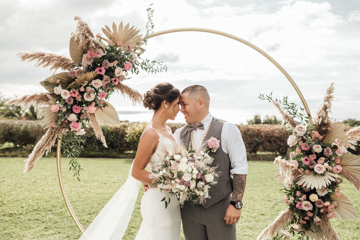 Elegant wedding ceremony setup with dried pampas grass and floral arrangements in neutral tones.