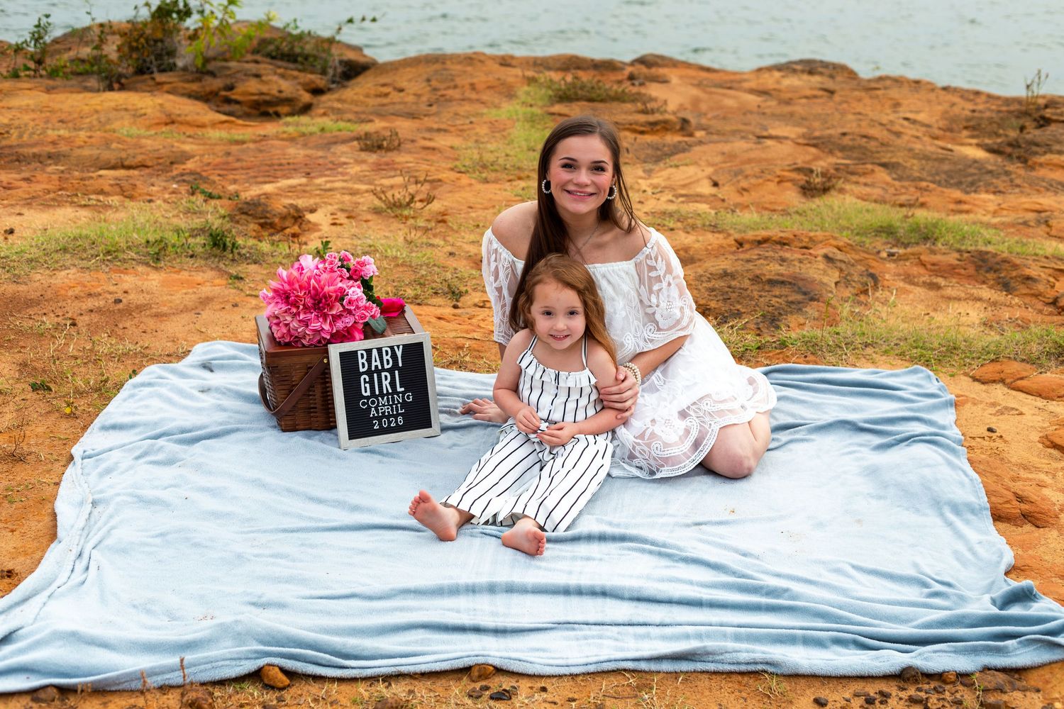 A series of outdoor maternity photo shoot scenes on red rocks with a blanket and sign board.