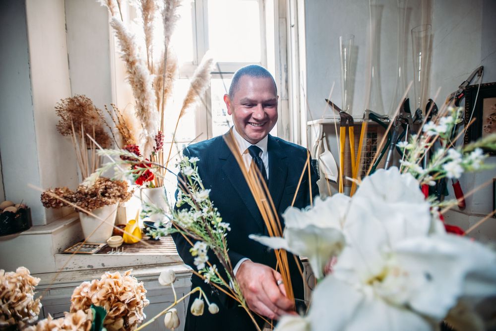 A wedding ceremony features elegant floral arrangements with white flowers and greenery on display at the venue.