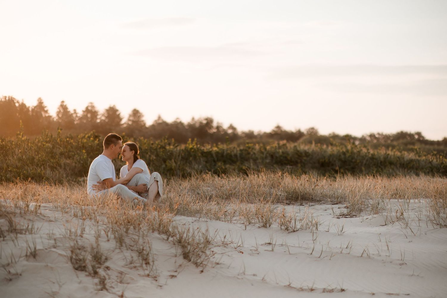 Couple sitting at Windang Beach in soft evening light