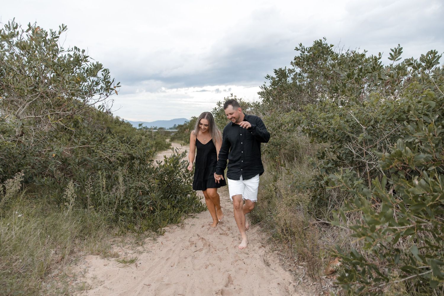 Couple walking along the secret pathway in Windang Beach in soft evening light