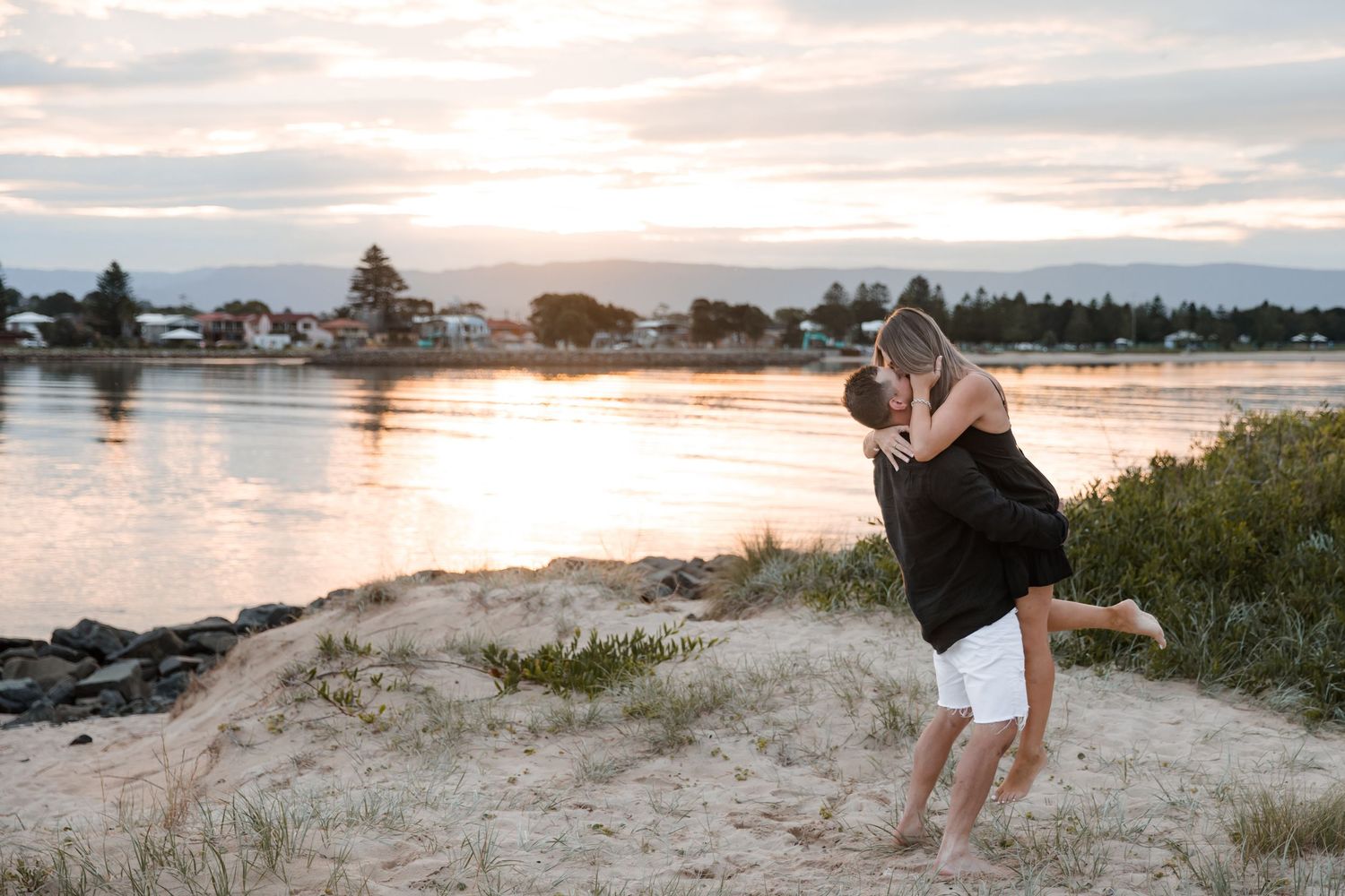 Couple hugging along Lake Illawarra and Windang Beach in soft evening light