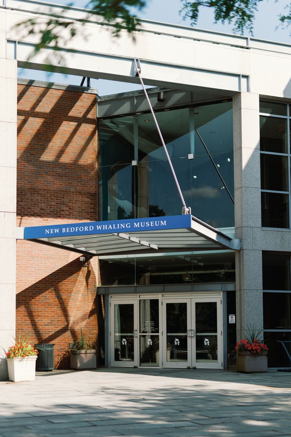 Exterior entrance of the New Bedford Whaling Museum with modern glass doors and brick facade.