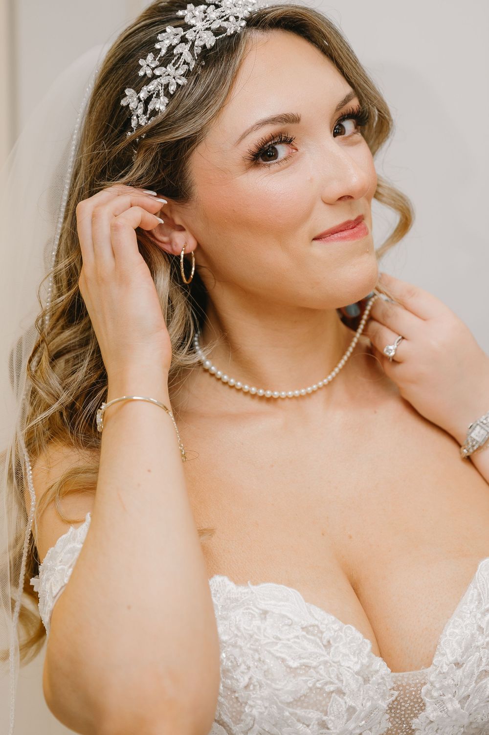 Elegant bridal portrait showing pearl necklace and crystal hair accessories with soft styling.
