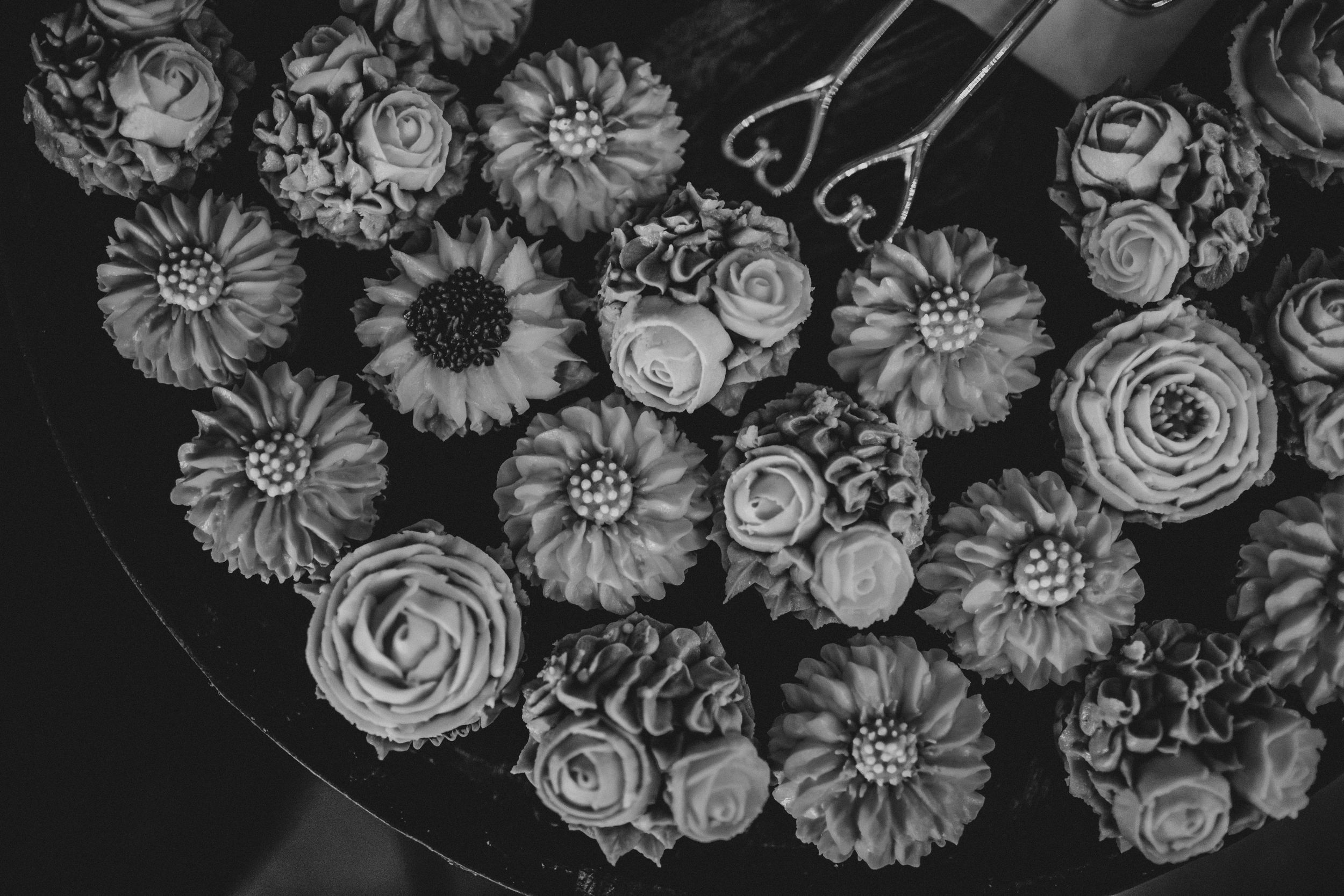 Black and white floral pattern featuring roses, daisies and other flowers in a repeating design arrangement.