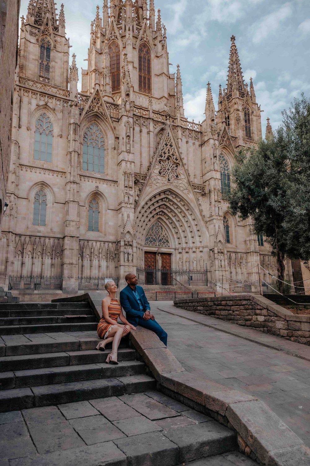 Stylish couple wearing semi-formal outfits for Barcelona vacation photos.