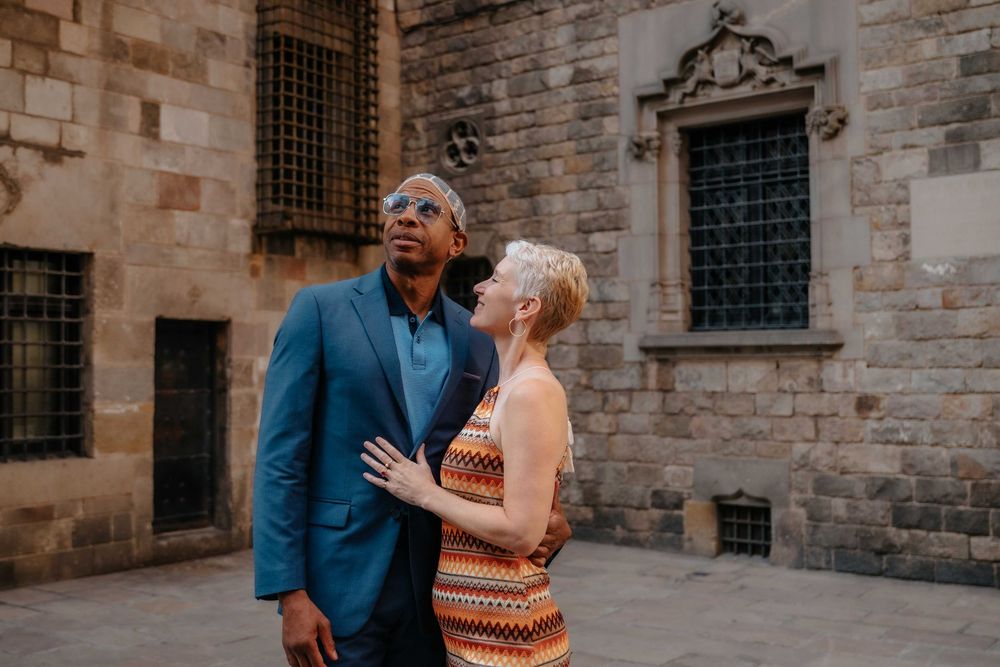 Sophisticated couple portrait in front of ancient stone walls Barcelona.