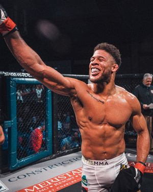 MMA fighter celebrating with enthusiasm after victory in the cage. live event photography st louis.