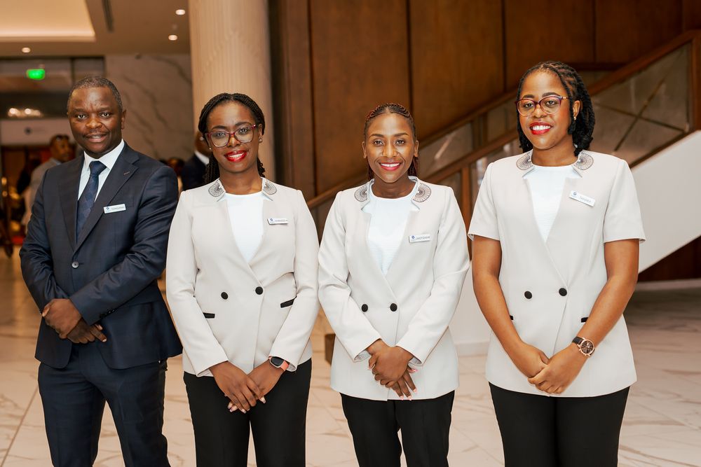A group of culinary professionals in white chef coats and black uniforms stand together in a line formation.