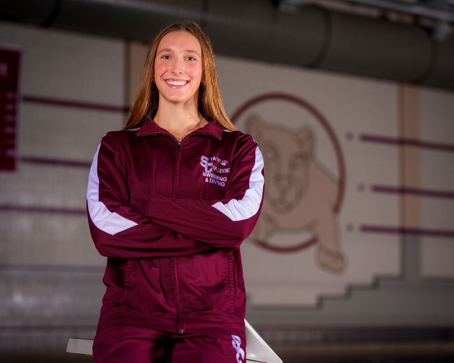 State College High School swimmer with maroon warmup and little Nittany Lion background, by SportsFox Photography, State College, PA
