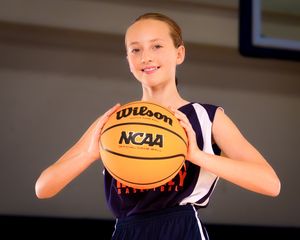 Youth basketball player in blue HYBA travel uniform holding basketball, individual portrait, team photo day.