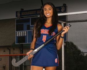 Hershey field hockey player in blue jersey, standing by goal, team photo day portrait, Hershey PA.