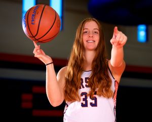 Hershey Middle School basketball player wearing jersey #33, smiling and holding basketball, team photo day portrait.