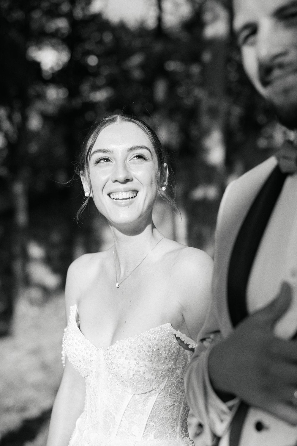A series of black and white portraits showing a bride in a white dress smiling joyfully.