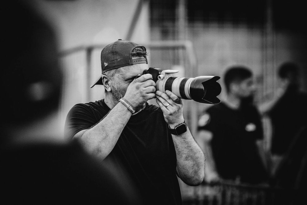 Fotograf fotí koncert a na hlave ma čapicu.