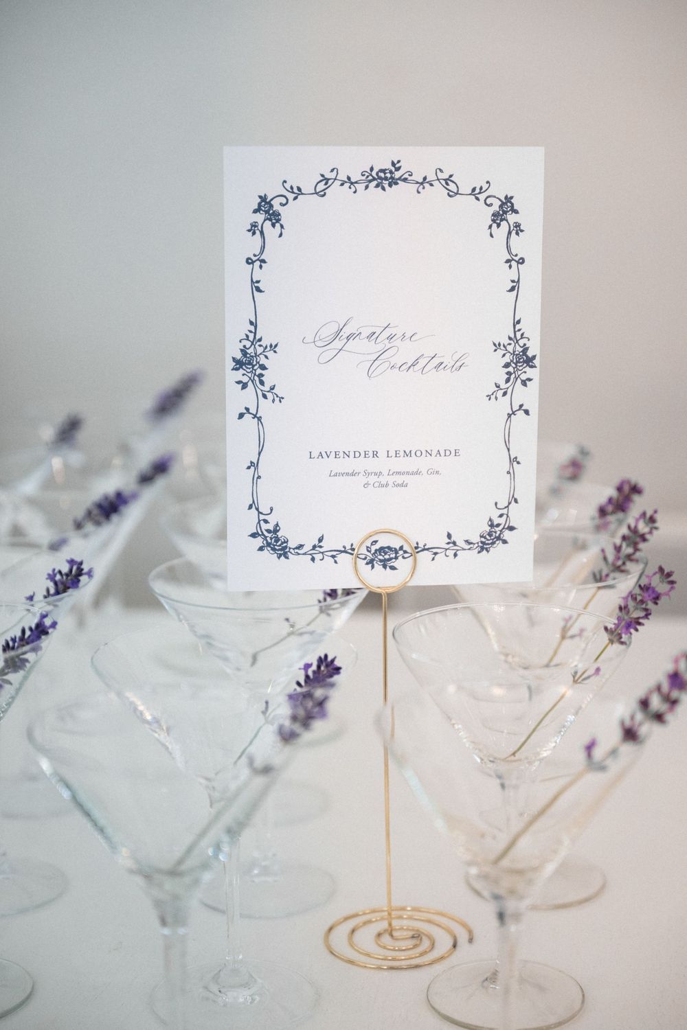 Elegant wedding place cards with lavender sprigs and delicate floral designs create a romantic table setting.