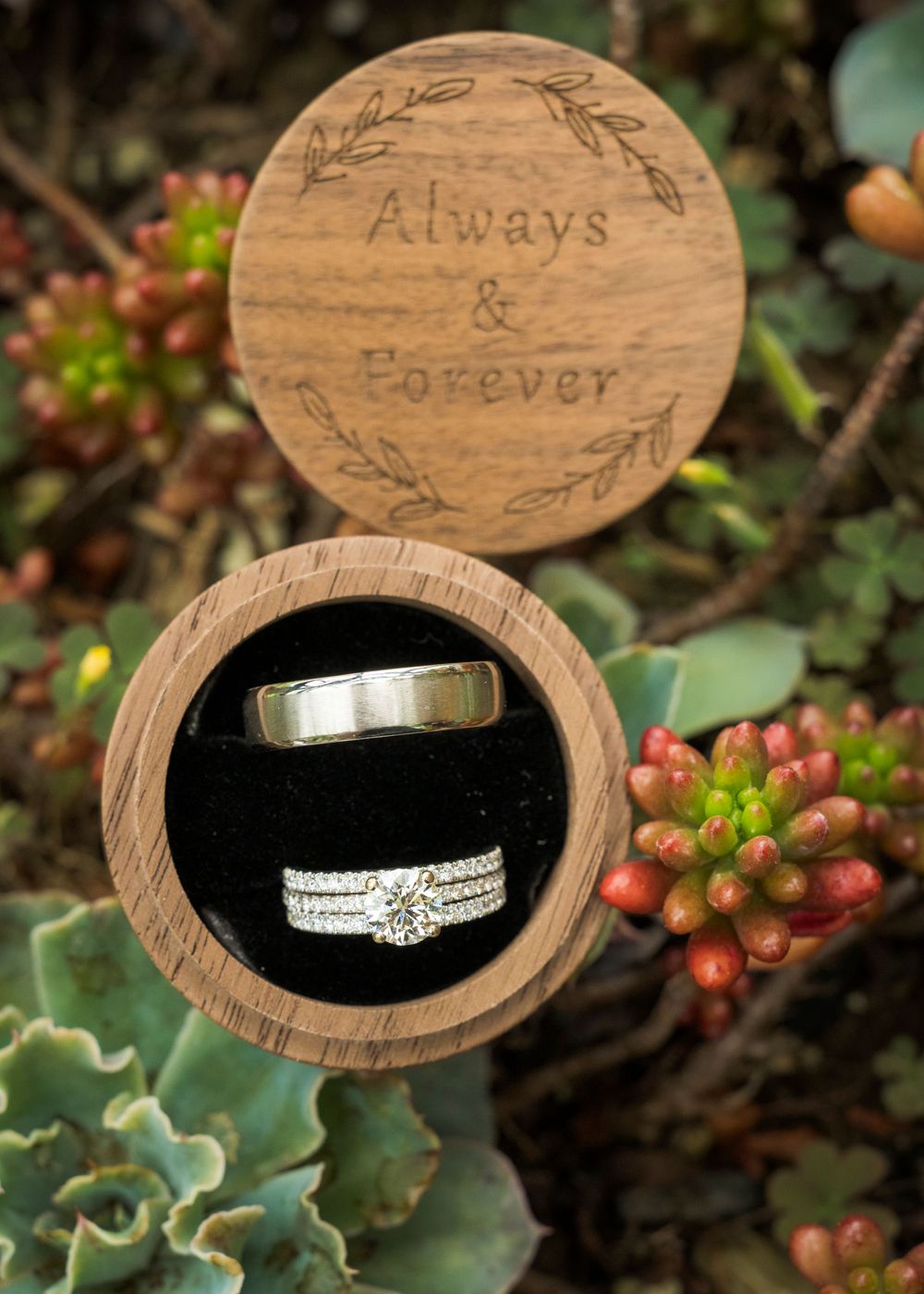 Wooden ring box engraved with Always and Forever holding wedding bands and diamond engagement ring.