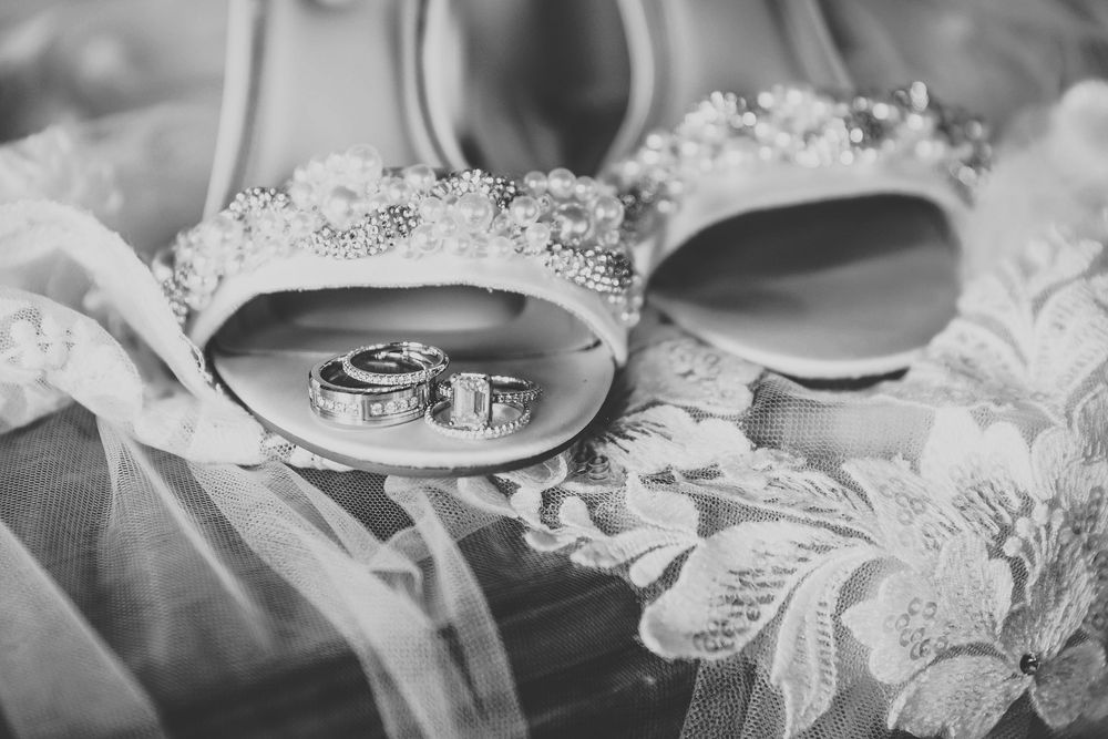 A black and white photograph shows delicate lace and fabric details in a close-up view.